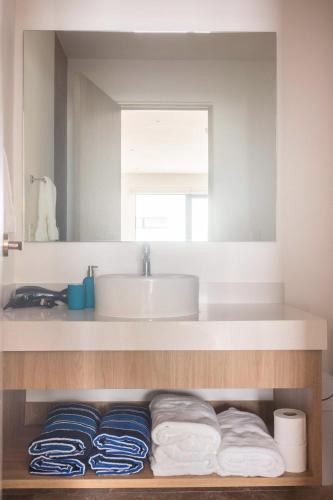 a bathroom with a sink and a counter with towels at Modern Studio close to the beah Pool and Fast WiFi in Playa del Carmen