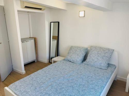 une chambre avec un lit avec deux oreillers bleus dans l'établissement Appartement T3, au Coeur de Montpellier, WIFI et Climatisation, à Montpellier