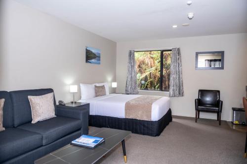 um quarto de hotel com uma cama e um sofá em 58 On Cron Motel em Franz Josef