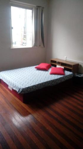 ラジェスにあるMini Hotel Calçadãoのベッドルーム1室(赤い枕のベッド1台、窓付)