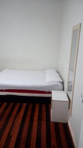 ラジェスにあるMini Hotel Calçadãoの小さなベッドルーム(ベッド1台、鏡付)