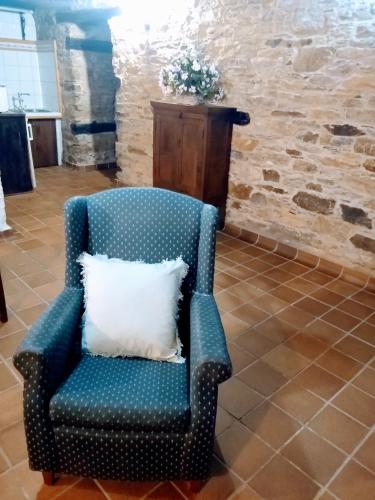 a blue chair with a white pillow in a room at Casa Pacios by M de Santiago in Tríacastela