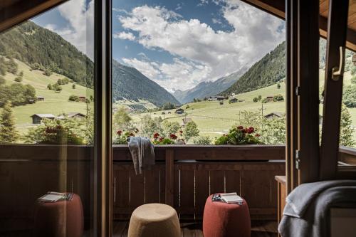 a room with a view of a valley from a window at Biohotel Rastbichlhof in Neustift im Stubaital