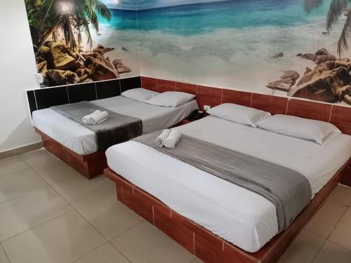2 Betten in einem Zimmer mit Wandgemälde in der Unterkunft HOTEL SENSACIONES SUITE in Medellín