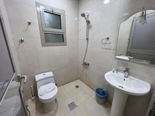 a bathroom with a toilet and a sink at ليالي الشرقية لشقق المخدومة in Dammam