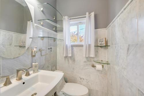 a bathroom with a sink and a toilet and a mirror at Trendy Baltimore Townhome 2 Mi to Downtown! in Baltimore