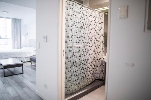Habitación con baño con ducha acristalada. en WeSleep Paraguay Departamentos en Microcentro en Buenos Aires