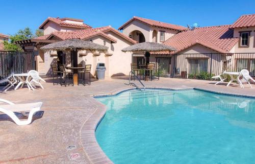a swimming pool with chairs and tables in front of a house at Beautiful San Felipe Getaway in La Ponderosa