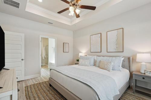 Highland ViewにあるPort St Joe Escape with Golf Cart and Pool Accessの白いベッドルーム(ベッド1台、天井ファン付)