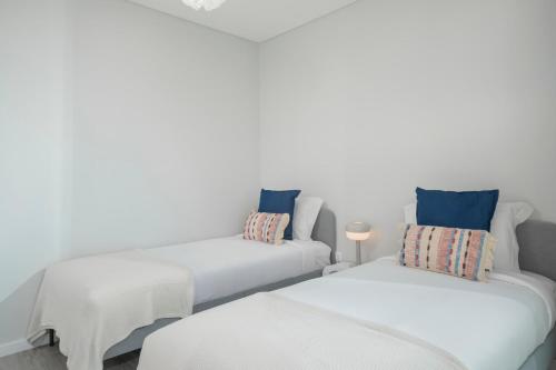 a white room with two beds and a couch at Vila Chu by An Island Apart in Ponta do Sol