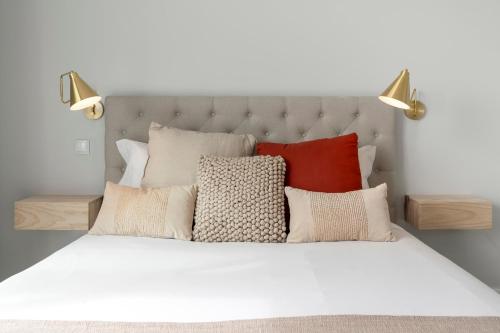 a white bed with a bunch of pillows on it at Vila Chu by An Island Apart in Ponta do Sol