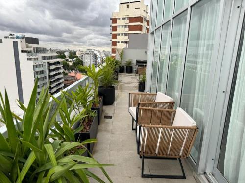 un balcón con sillas y plantas en un edificio en Penthouse a estrenar en Sofisticado Barrio y Edificio Nov 2023 Vista panorámica 100m2 Gimnasio Piscina Lujoso Salon de Fiestas en Buenos Aires