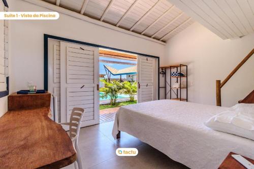 a bedroom with a bed and a door to a patio at Vila Fortunata Pontal do Maceió Fortim c/ Mirante in Fortim