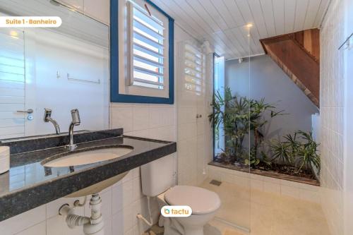 a bathroom with a toilet and a sink and a window at Vila Fortunata Pontal do Maceió Fortim c/ Mirante in Fortim
