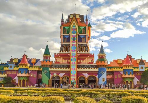 a large colorful building with people standing in front of it at Pousada Ametista - Penha, SC - 1,5 km do Parque Beto Carrero World in Penha
