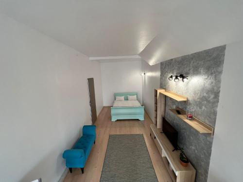 a small room with a bed and a blue chair at Compact House in Cluj-Napoca