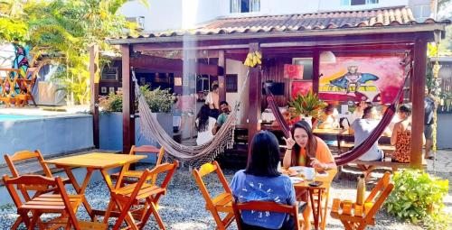two women sitting at a restaurant with hammocks at Che Lagarto Paraty in Paraty
