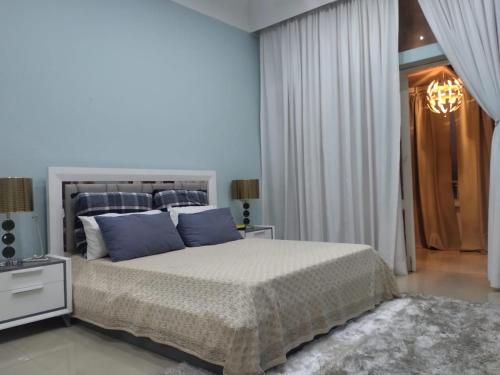 a bedroom with a large bed with blue pillows at A vista perfeita in Luanda