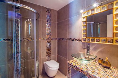 uma casa de banho com um chuveiro, um WC e um lavatório. em Lilac Lilium Artistsvillas em Gaios