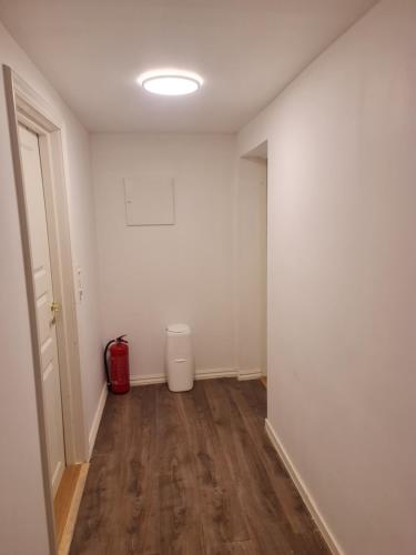 an empty room with a red trash can in it at leilighet med 2 soverom på kløfta in Klofta