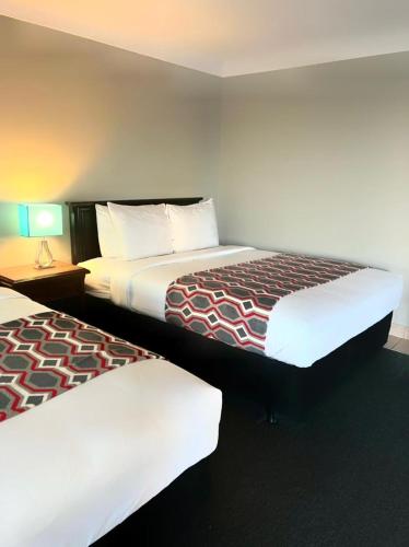 a hotel room with two beds and a table with a lamp at City View Inn in Burlington