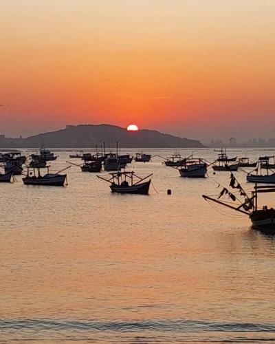 a group of boats in the water at sunset at Pousada Ametista - Penha, SC - 1,5 km do Parque Beto Carrero World in Penha