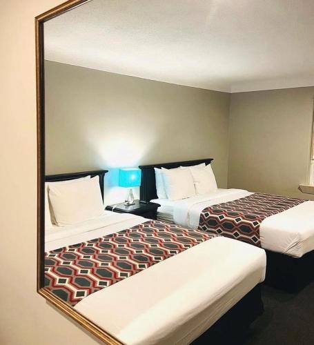 espejo que refleje 2 camas en una habitación de hotel en City View Inn, en Burlington