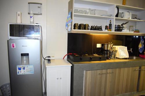 a kitchen with a refrigerator and a stove in it at A tastefully furnished one bedroom airbnb apartment along Thika rd, TRM mall in Nairobi