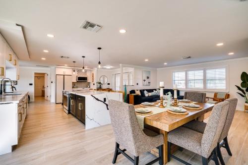 a kitchen and living room with a wooden table and chairs at Waterfront Fort Myers Home Private Pool and Dock in Fort Myers