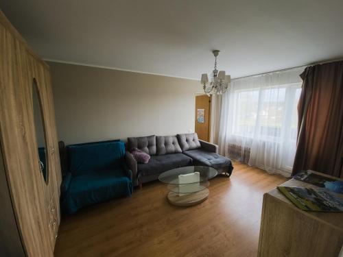 ein Wohnzimmer mit einem Sofa und einem Tisch in der Unterkunft Nikodema in Krāslava