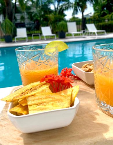 a plate of nachos and a drink next to a pool at Domaine Saint-François in Saint-François