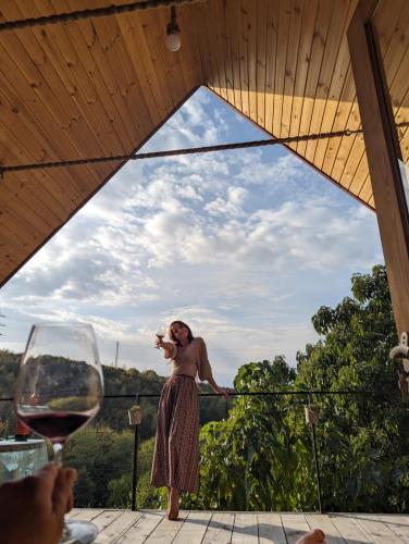 Una donna in piedi su un tavolo che beve un bicchiere di vino di LIMA a Kutaisi