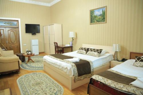 a hotel room with two beds and a tv at ALMOS in Dushanbe