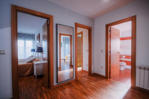 a room with two mirrors and a bedroom with a bed at Villa Tiviti in Oviedo