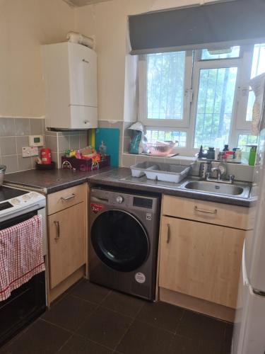 a kitchen with a washing machine and a sink at Vivian House in London