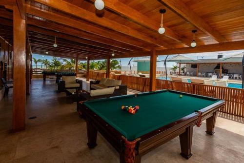 a pool table in the middle of a room with a swimming pool at Hotel Boutique Caleta Grau in Zorritos
