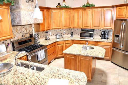 a kitchen with wooden cabinets and stainless steel appliances at Southwestern Comfort Stay 2B in Las Cruces
