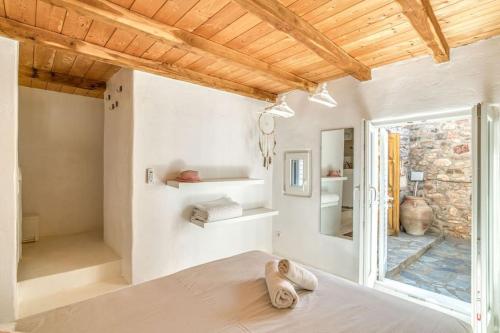 una camera da letto con pareti bianche e soffitto in legno di Villa Finca - Atypical a Pounda