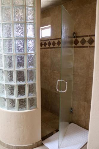 a shower with a glass door next to a window at Southwestern Comfort Stay 2B in Las Cruces