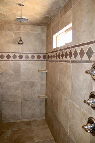 a tiled bathroom with a shower with a window at Southwestern Comfort Stay 2B in Las Cruces