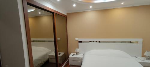 Dormitorio pequeño con cama y espejo en Reis Magos Beach Caniço Sea line Apartment, en Caniço