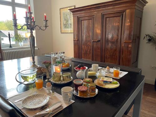 un tavolo per la colazione con cibo e succo d'arancia sopra di Villa Krafft Bed&Breakfast a Waake