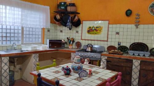 uma cozinha com uma mesa, um lavatório e um fogão em Quinta Villamarin em Chiconcuac