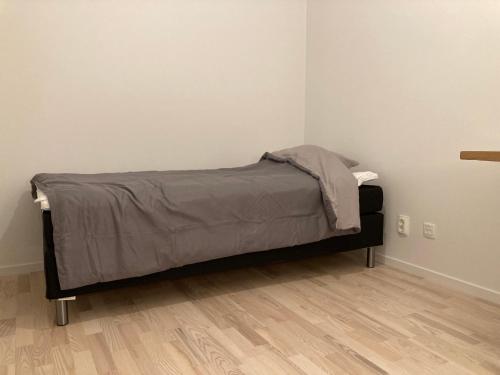 uma cama com um cobertor num quarto em Cozy Room em Borås