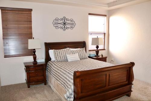 um quarto com uma cama e duas mesas de cabeceira e uma janela em Beautiful and Comfortable Southwestern Home 1 em Las Cruces