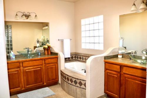 uma casa de banho com 2 lavatórios e uma banheira em Beautiful and Comfortable Southwestern Home 1 em Las Cruces