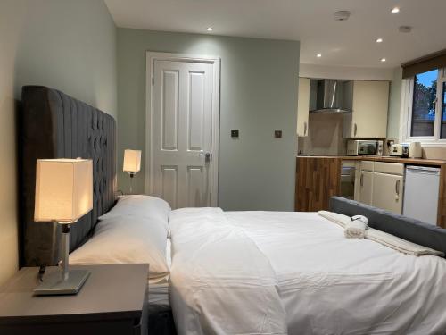 1 dormitorio con 2 camas y mesa con lámpara en Cosy Studio Flat with Balcony in Heart of London, en Londres