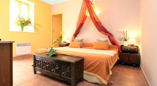 a bedroom with a bed with a canopy at La Treille in Vitrac