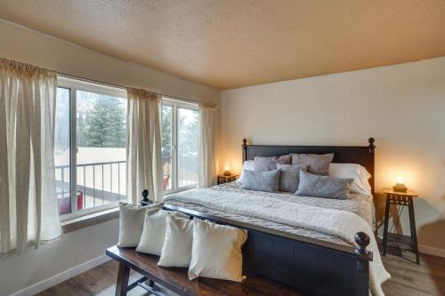 een slaapkamer met een groot bed met kussens en ramen bij Brian Head Studio Condo with Balcony and Mountain View in Brian Head