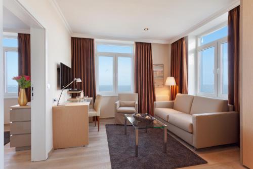 a living room with a couch and a table at Strandhotel Georgshöhe in Norderney
